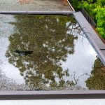 Ponding standing water on a flat roof after heavy rain